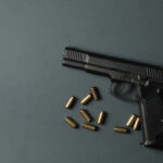 pistol and traumatic bullets on dark gray backgrou 2021 09 02 21 43 40 utc